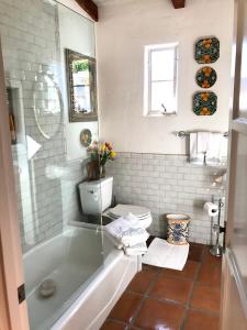 a bathroom with a tub and a toilet at Casa De Vito in Palm Springs