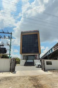 un gran edificio con un cartel encima en Hotel Harigardenia - Airport Mattuthavani ring road, Near Meenakshi Mission Hospital, Madurai, en Tallākulam