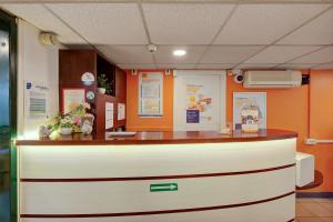 a counter in a room with orange walls at Premiere Classe Rouen Sud - Parc Des Expositions in Saint-Étienne-du-Rouvray