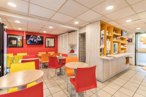 une salle à manger avec des tables et des chaises dans un restaurant dans l'établissement Premiere Classe Rouen Sud - Parc Des Expositions, à Saint-Étienne-du-Rouvray