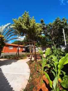 a garden with a wooden gate and a sidewalk at Pousada Vila Tadeu in São João Batista do Glória