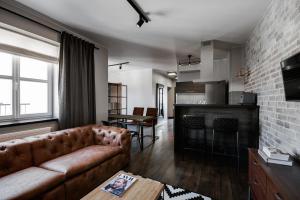 Una sala de estar con un sofá y una chimenea. en Too-Good Apartments, en Cracovia