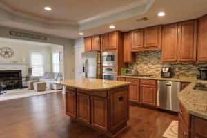 a kitchen with wooden cabinets and a living room at 38815 Cedar Waxwing La Bay Forest Bethany in Ocean View