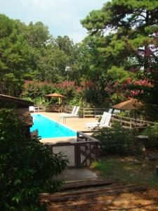 a swimming pool with lounge chairs and umbrellas at Mountain Harbor Queen Guest Room on Lake Ouachita in Mount Ida