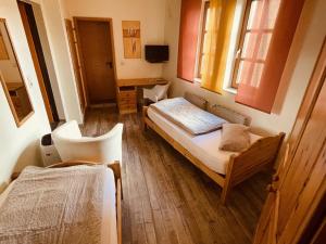 a room with two beds and a desk and a chair at Zum Alten Krug in Naumburg