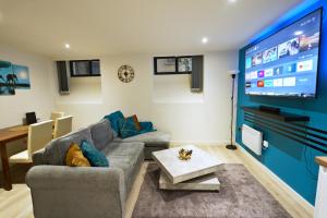 ein Wohnzimmer mit einem Sofa und einem Flachbild-TV in der Unterkunft NEW Luxury NYC Style Loft with Cinema Room in Bradford