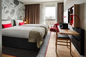 a hotel room with a large bed and a desk at IntercityHotel Karlsruhe in Karlsruhe