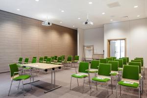 a conference room with green chairs and tables at IntercityHotel Karlsruhe in Karlsruhe