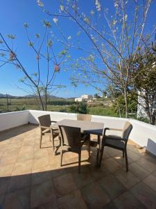 eine Terrasse mit einem Tisch und Stühlen auf dem Dach in der Unterkunft Nikos Country House in Naoussa