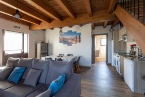 ein Wohnzimmer mit einem grauen Sofa und einer Küche in der Unterkunft Villas, El Mirador de Isla in Isla