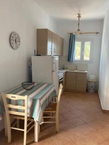 a kitchen with a table and a white refrigerator at Nikos Country House in Naousa