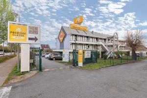 um edifício com um sinal em frente em Premiere Classe Rouen Sud - Parc Des Expositions em Saint-Étienne-du-Rouvray