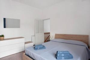 um quarto com uma cama com toalhas azuis em Da Chicca em Bolano
