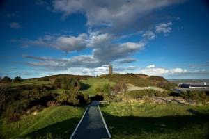 una carretera que conduce a una colina con un faro en ella en Converted cattle barn overlooking Strangford Lough, en Newtownards