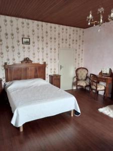 Panjas的住宿－Maison de campagne Les Chênes.，卧室配有一张床和一张桌子及椅子
