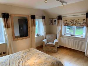 Stunning 2-Bed cottage Rye East Sussex في راي: غرفة نوم بسرير وكرسي ونوافذ