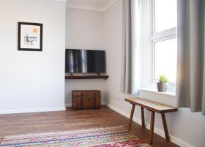 a living room with a television and a wooden table at IndieHaus in Lincolnshire