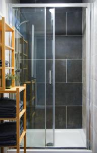a shower with a glass door in a bathroom at IndieHaus in Lincolnshire