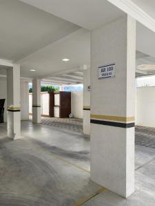 an empty building with a column with a sign on it at Apto com Piscina, Estacionamento e Churrasqueira em Bombas - 2 dorms 6 pessoas - 300 metros do Mar in Bombinhas