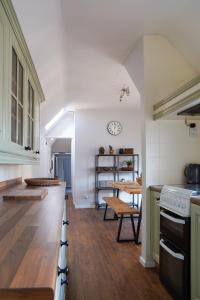 a kitchen with white walls and a wooden floor at IndieHaus in Lincolnshire