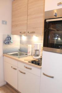 een keuken met een witte koelkast en een wastafel bij "Haus Sonnenschein - Whg 3" familiengerechte Wohnung mit 2 SZ und Terrasse in zentraler Lage in Grömitz