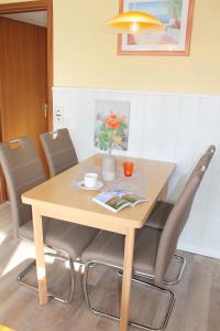 格洛米茨的住宿－"Haus Sonnenschein - Whg 3" familiengerechte Wohnung mit 2 SZ und Terrasse in zentraler Lage，餐桌、椅子和木桌