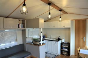 a kitchen with white cabinets and lights on the ceiling at AquaHause in Pataias