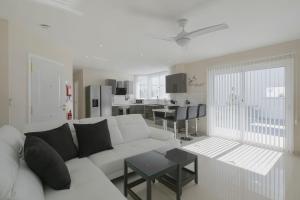 a white living room with a white couch and a table at Stunning Apartment - Near Los Cristianos in Chayofa