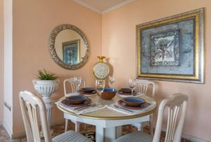 a dining room with a table with chairs and a mirror at 1 Line Beachfront Apartment with stunning sea view in Sitio de Calahonda