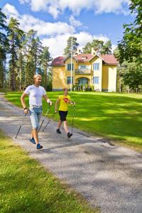 Una mujer y un niño caminando por un camino en Villa Urhola, Kruunupuisto, en Punkaharju 16 fotos más