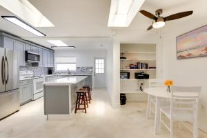 a kitchen with white cabinets and a ceiling fan at Airy Bradenton Vacation Rental with Patio, Gas Grill in Bradenton