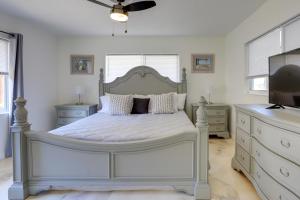 a bedroom with a white bed and a television at Airy Bradenton Vacation Rental with Patio, Gas Grill in Bradenton