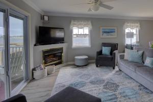 sala de estar con sofá, TV y chimenea en 30399 Pavillion Drive, en Ocean View