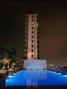 ein hohes Gebäude in der Nacht mit Pool davor in der Unterkunft MHA 15 SUlTE EVO SOHO BANDAR BARU BANGI FREE NETFLIX AND WIFI in Bandar Baru Bangi