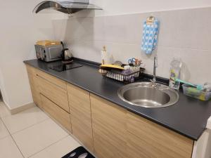 a kitchen with a sink and a counter top at MHA 15 SUlTE EVO SOHO BANDAR BARU BANGI FREE NETFLIX AND WIFI in Bandar Baru Bangi