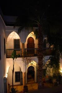 a building with a palm tree in front of it at Riad Al Faras in Marrakesh