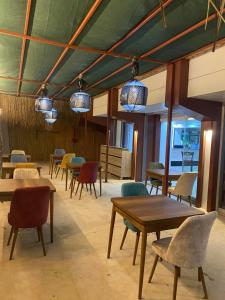 ein Esszimmer mit Tischen, Stühlen und Lichtern in der Unterkunft Marla Didim Otel in Didim