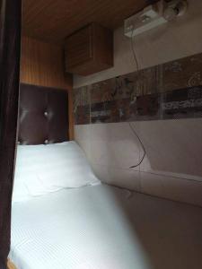 1 dormitorio con 1 cama blanca en una habitación en SD Hostel AC Deluxe, en Bombay