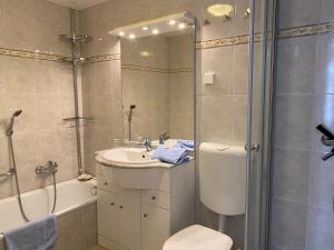 a bathroom with a toilet and a shower and a sink at Apartmenthaus am Watt Büsum in Büsum +106 photos