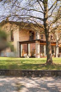 une maison avec un arbre en face dans l'établissement Fenil Conter Cottage & Suite, à Pozzolengo