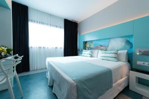 - une chambre avec un grand lit et un mur bleu dans l'établissement Sercotel Puerto de la Luz, à Las Palmas de Gran Canaria