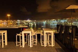 un grupo de mesas y sillas en un balcón por la noche en Sercotel Puerto de la Luz, en Las Palmas de Gran Canaria