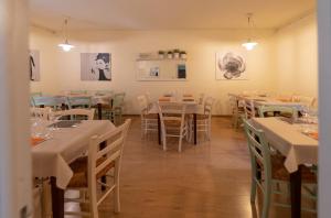 un comedor con mesas y sillas con manteles blancos en IL Borgo Ristorante Pizzeria Camere, en Acquapendente