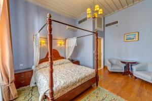 Apollonion Palace في إرموبولّي: غرفة نوم مع سرير بأربعة أعمدة وطاولة