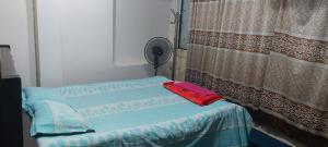 Habitación con 2 camas, ventilador y ventana. en Kompass Homestay - Affordable AC Room With Shared Bathroom in Naya Paltan Free WIFI en Dhaka