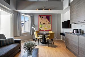 a living room with a table and a kitchen at numa l Topp Apartments in Oslo