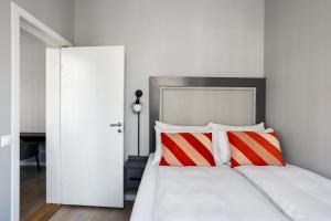 um quarto com uma cama com almofadas vermelhas e brancas em numa l Topp Apartments em Oslo