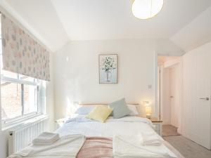 a white bedroom with a bed and a window at Garway Cottage in Ross on Wye