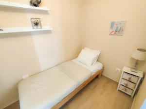 een kleine kamer met een bed en een lamp en planken bij Precioso apartamento en Los Cristianos in Los Cristianos