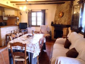 uma sala de jantar com uma mesa e uma lareira em La Casita de Piedra em Ronda